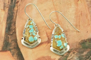 Genuine Number 8 Mine Turquoise Stones set in Sterling Silver French Wire Earrings. The Number 8 mine is located in Eureka County Nevada. Since 1976 there has been no Number 8 Turquoise mined. There is however, an existing stock pile that Mr. Dowell Ward, the last owner of the Number 8 mine, had stocked away for later sorting. The Turquoise is a collector's item--because once the reserve is gone there will be no more material released onto the market. The Gold Mining Company owns the claim to the Number 8 mine and it has been swallowed up by the gold mining operations. This is some of the last Number 8 Turquoise to be had and will be a great addition to your collection. Created by Navajo Artist Arkie Nelson. Signed by the artist.