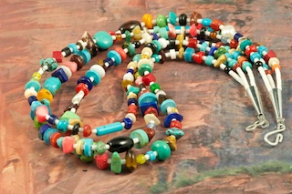 Beautiful 3 strand Treasure Necklace featuring Genuine Turquoise, Spiny Oyster Shell, Coral, Freshwater Pearls, Jasper and Melon Shell Heishi.  Sterling Silver Cones and Clasp.  Created by Santo Domingo Artist Carol Pacheco. The Santo Domingo Pueblo is in New Mexico, near Santa Fe. 