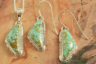 Genuine Number 8 Mine Turquoise Stones set in Sterling Silver. Beautiful Pendant and Earrings Set with an 18" Sterling Silver Chain. Created by Navajo Artist Larson Lee. Signed by the artist. The Number 8 mine is located in Eureka County Nevada. Since 1976 there has been no Number 8 Turquoise mined. There is however, an existing stock pile that Mr. Dowell Ward, the last owner of the Number 8 mine, had stocked away for later sorting. The Turquoise is a collector's item--because once the reserve is gone there will be no more material released onto the market. The Gold Mining Company owns the claim to the Number 8 mine and it has been swallowed up by the gold mining operations. This is some of the last Number 8 Turquoise to be had and will be a great addition to your collection. 